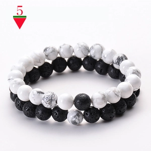Detail of beaded bracelet set with white turquoise stones and black matte lava rock beads
