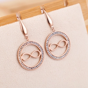 Boucles d'oreilles cercle infini or rose avec cristaux sur carte de présentation beige