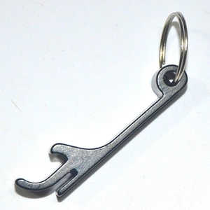 Macro shot of dark gray aluminum alloy key-shaped bottle opener with sturdy keyring