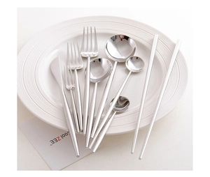 Detailed top view of 9-piece polished 304 stainless steel cutlery set on a white spiral plate