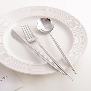 Polished silver 304 stainless steel cutlery set with knife, fork, and spoon on white plate