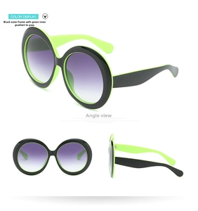 Detail of oversized round sunglasses with dual-layer black and neon green frames