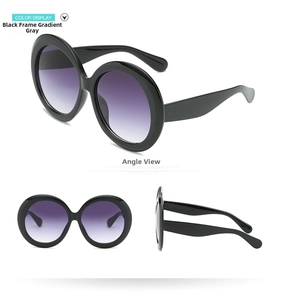 Detail view of oversized retro round sunglasses with black frame and purple gradient lenses