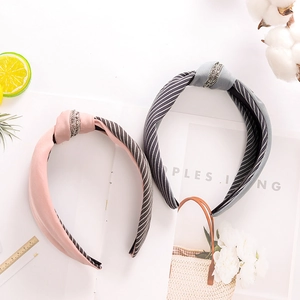 Close-up of pink and grey knotted fabric headbands with sparkling rhinestone details