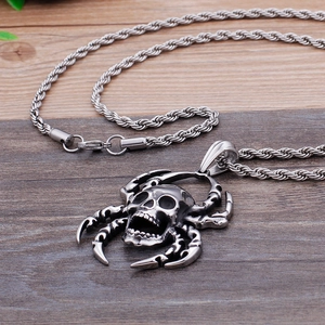 Punk style stainless steel skull pendant necklace with spider legs on wood surface