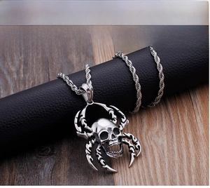 Detailed close-up of a punk spider skull pendant with a twisted stainless steel chain