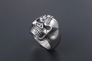 Macro shot of silver metal skull ring detailing intricate facial features and teeth
