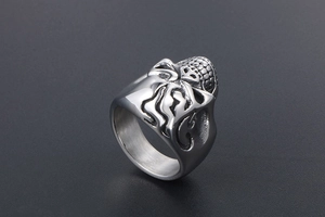 Detailed close-up of a silver skull ring for men with intricate flame patterns