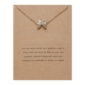 Golden guardian angel wing pendant necklace displayed on brown greeting card package