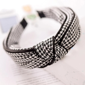Close-up of black and white houndstooth fabric headband with a stylish knotted detail