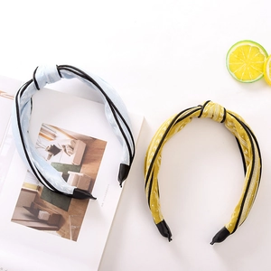 Detail of knotted headbands in light blue and mustard yellow with patterned fabric textures