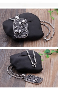Macro detail of punk skull pendant necklace featuring vintage embossed silver finish