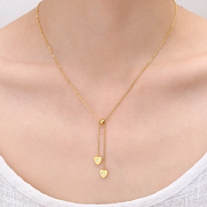 18K gold-plated titanium steel necklace with asymmetrical zircon heart pendants on a model