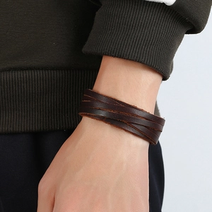 Close-up of multi-layer dark brown woven leather bracelet on wrist for a retro look