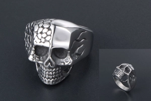 Detail of silver skull ring featuring unique hexagonal grid texture and smooth metal finish