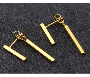 Macro view of polished 18k rose gold steel double square bar earrings in minimalist style