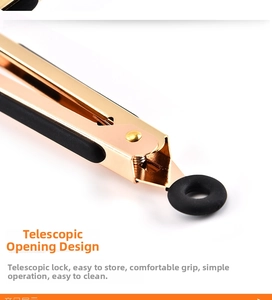 Detail of gold plated food tongs showing the locking pull ring and black silicone handle