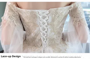 Detail of bridal gown featuring intricate gold lace embroidery and adjustable corset back