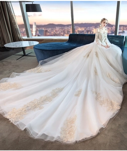 Exquisite off-the-shoulder wedding gown featuring gold floral embroidery and long cathedral train