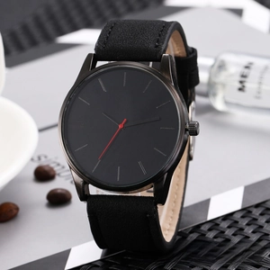 Macro detail of minimalist black watch dial with striking red second hand and suede strap