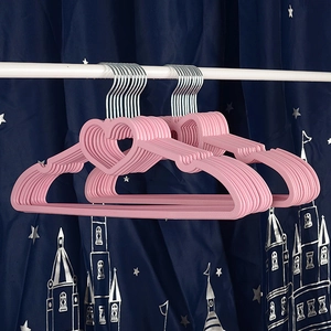 Detail of pink heart-shaped plastic hangers with metal hooks stacked on a white closet rod