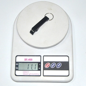 Tiger-shaped alloy bottle opener weighing 11.1 grams on a digital scale for measurement