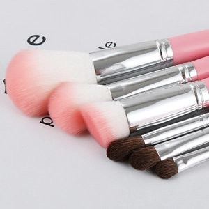 Detailed close-up of premium pink makeup brushes with soft bicolor synthetic bristles