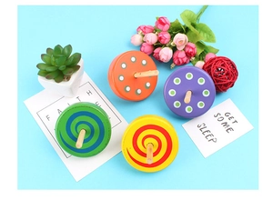 Top view of four colorful wooden spinning tops with polka dots and spiral patterns