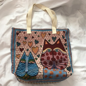 Close-up of woven tapestry tote bag with stylized cat patterns and colorful hearts