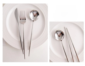 Macro detail of polished stainless steel cutlery set on a minimalist white ceramic plate
