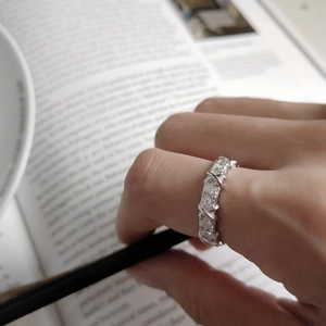 Macro shot of 925 silver multi-layer crisscross ring with sparkling pavé diamonds on finger