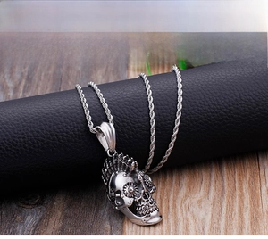 Close-up of gothic skull pendant with detailed engraving on silver rope chain
