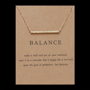 Close-up of golden cat ear alloy pendant necklace on brown kraft balance paper card