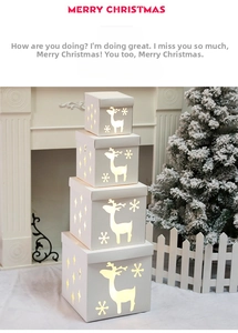 Detail of white hollowed Christmas gift boxes with reindeer patterns and warm lights