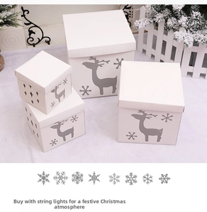 Detailed view of white Christmas gift boxes with reindeer and snowflake cut-out patterns