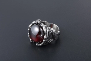 Detailed close-up of retro dragon claw ring with red gemstone and oxidized silver finish