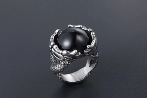 Detailed view of dragon claw ring holding a polished black orb in vintage titanium steel