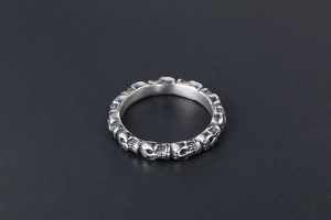 Macro detail of vintage punk silver titanium steel ring with skull pattern reliefs