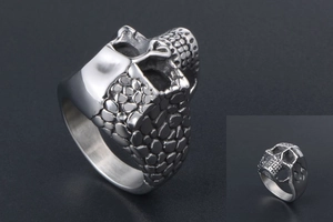 Detail of silver titanium ring with rock style skull texture and polished finish