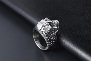Macro detail of silver titanium steel ring featuring double skull rock style texture