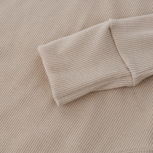Macro di maglia a coste beige che mostra la trama dettagliata della cucitura del polsino