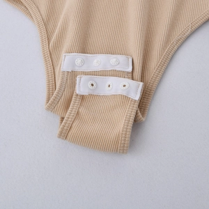 Dettaglio del cavallo del body a costine beige con pratica chiusura con bottoni a pressione