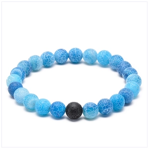 Détail de perles d'agate bleue de 8mm et pierre de lave noire sur bracelet élastique