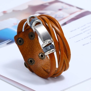 Close-up of multilayered brown leather woven bracelet with silver metallic buckles