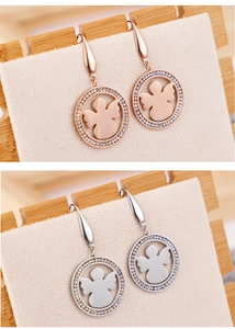 Vue macro de boucles d'oreilles anges circulaires en or rose et argent avec strass incrustés