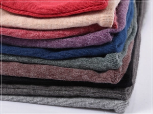 Close-up of neatly folded thermal wool-blend knit beanies in various vibrant colors