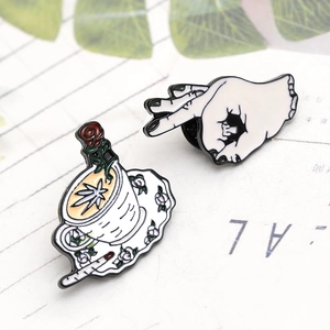 Detail of enamel rose coffee cup and OK hand gesture pins with fine zinc alloy textures