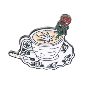 Detail of enamel pin featuring rose coffee cup with herbal leaf latte art and cigarette