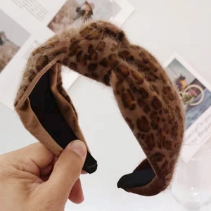 Detail of leopard print plush wide headband showing soft texture and knotted top design