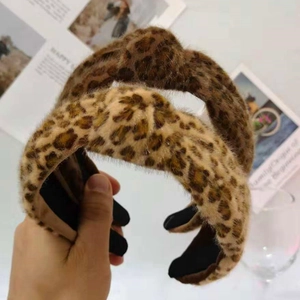 Detail of plush leopard print headbands in brown and beige with stylish knot design